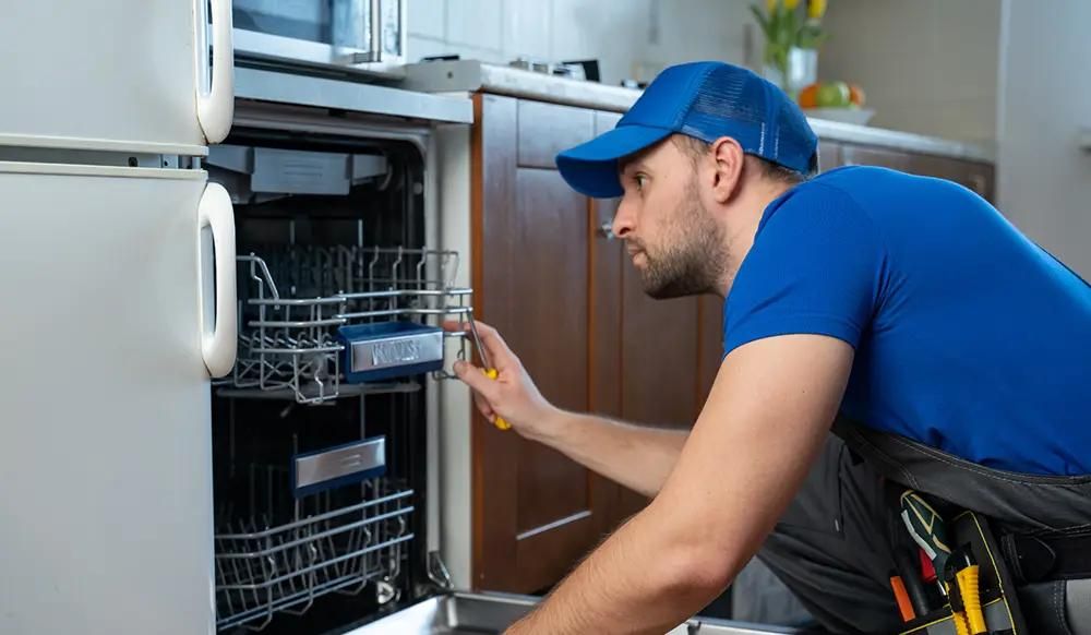Handyman looking at a broken dishwasher
